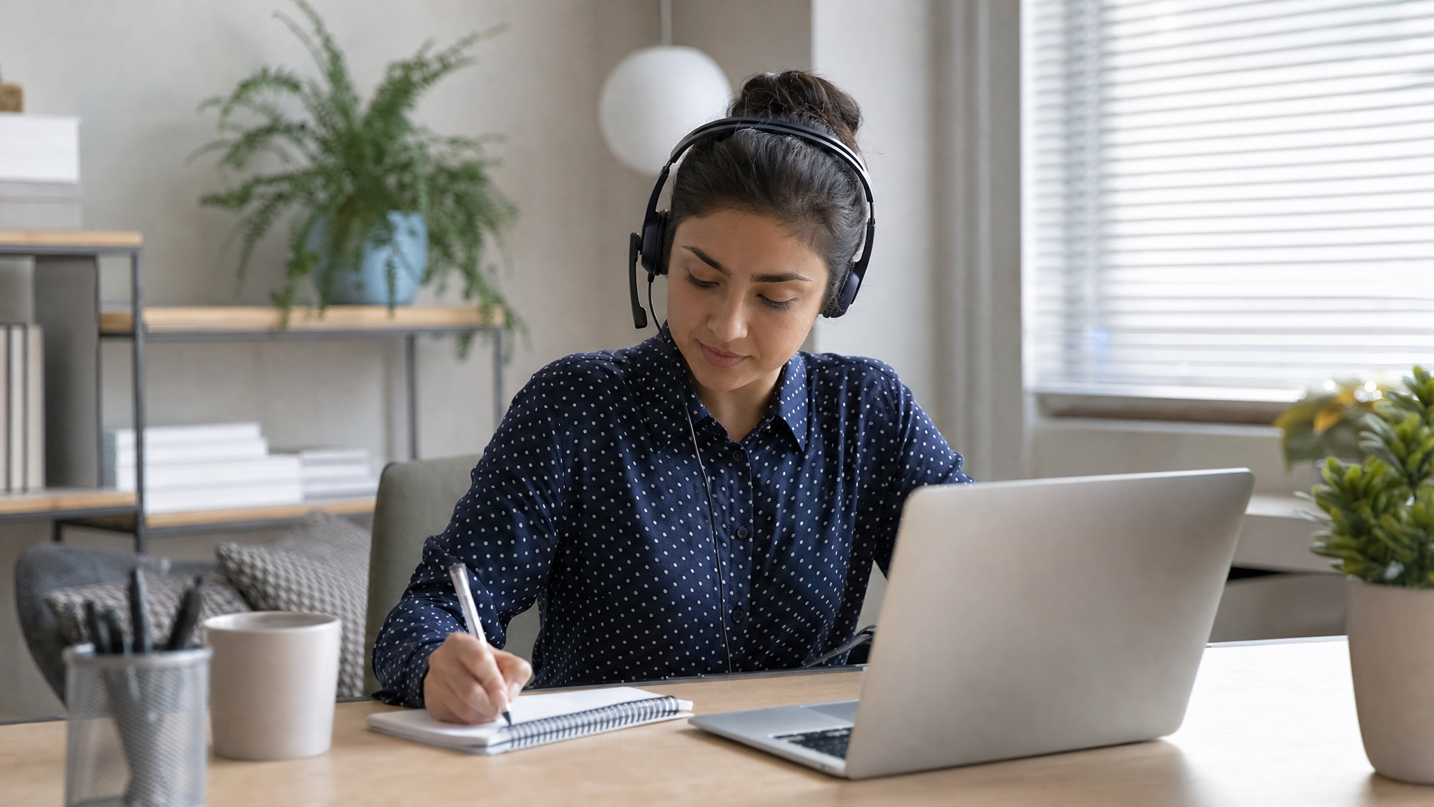 Remote worker taking notes at a home desk